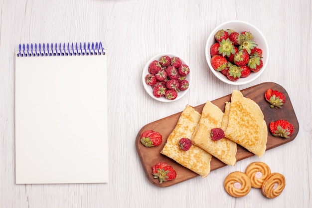 Draufsicht auf leckere süße Pfannkuchen mit Früchten auf Weiß