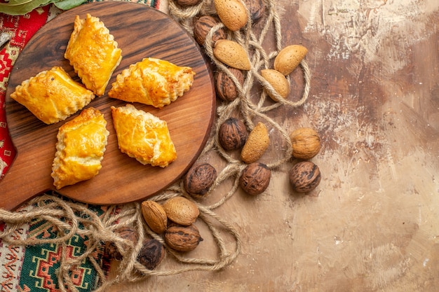 Draufsicht auf leckeres Nussgebäck mit frischen Walnüssen auf dem braunen Schreibtisch