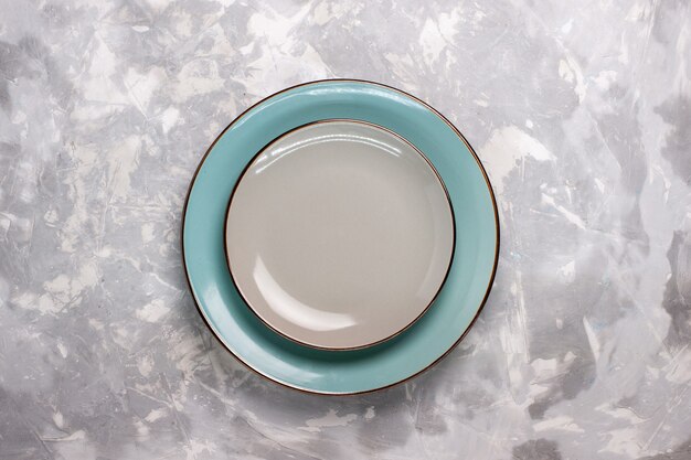Draufsicht auf leere Platten aus Glas auf weißer Oberfläche