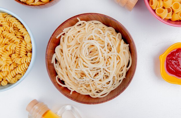 Draufsicht auf Makkaroni als Spaghetti Rotini und Pipe-Rigate mit Ketchup auf weißer Oberfläche