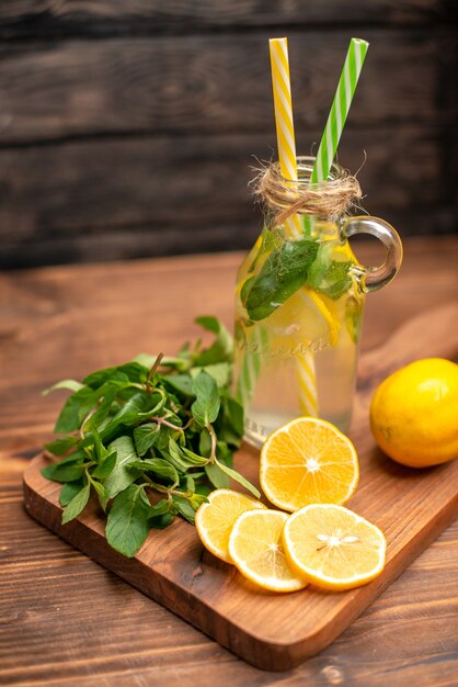 Draufsicht auf natürliches frisches Detox-Wasser, serviert mit Tuben Minze und Orange auf einem Holztisch