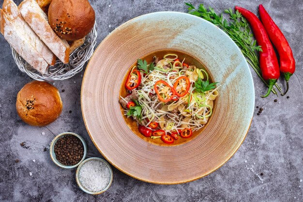 Draufsicht auf Nudeln mit Rindfleisch garniert, Chili-Pfeffer-Zwiebel und geriebenem Käse