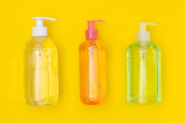 Draufsicht auf Plastikflaschen mit Händedesinfektionsmittel und Flüssigseife