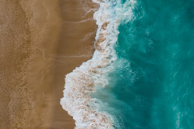 Draufsicht auf Sand, der Meerwasser trifft