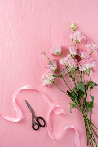 Draufsicht auf schöne Rosen mit Schere und Band