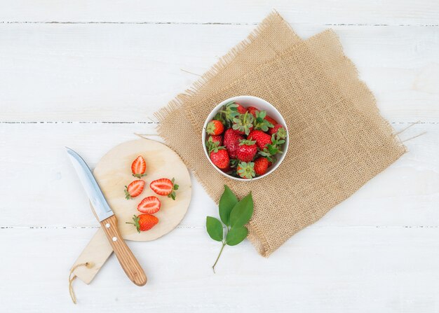 Draufsicht auf Schüssel und Teller mit Erdbeeren