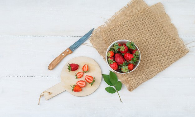 Draufsicht auf Schüssel und Teller mit Erdbeeren