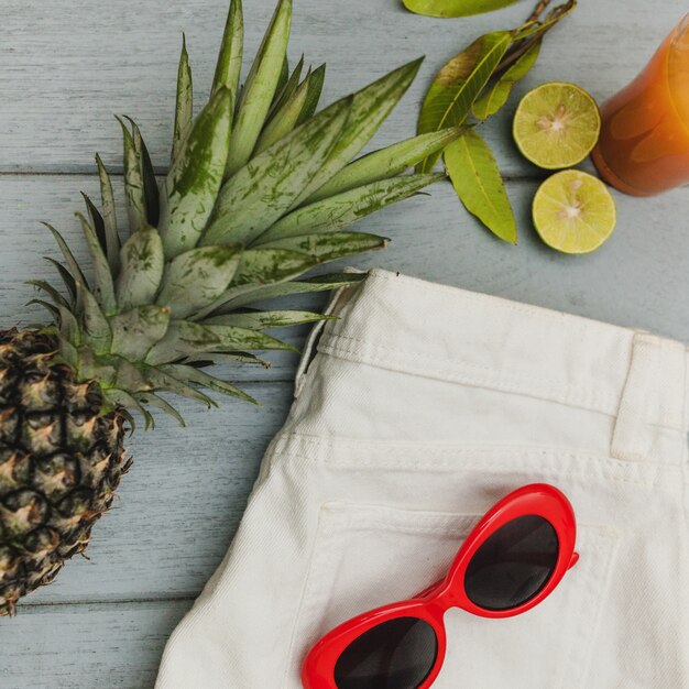 Draufsicht auf Sommerelemente und Ananas auf Holzoberfläche