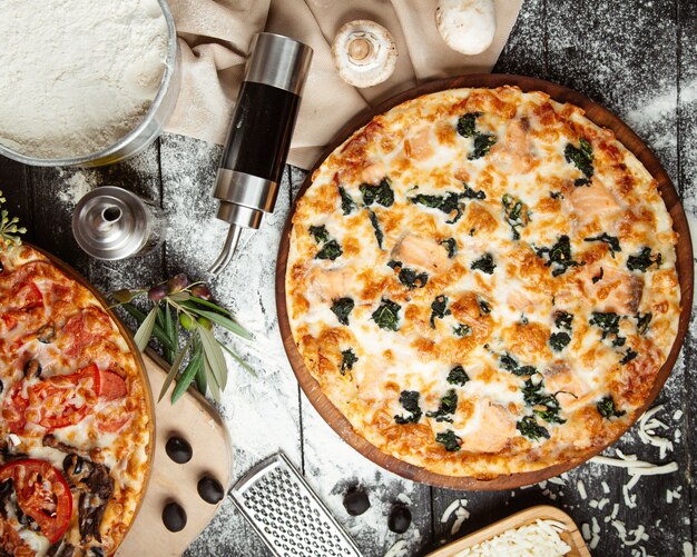 Draufsicht auf Spinatpizza und die Hälfte der Mischpizza