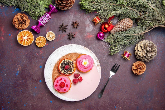 Draufsicht auf süße leckere Kuchen mit Sahne und Früchten auf Schwarz