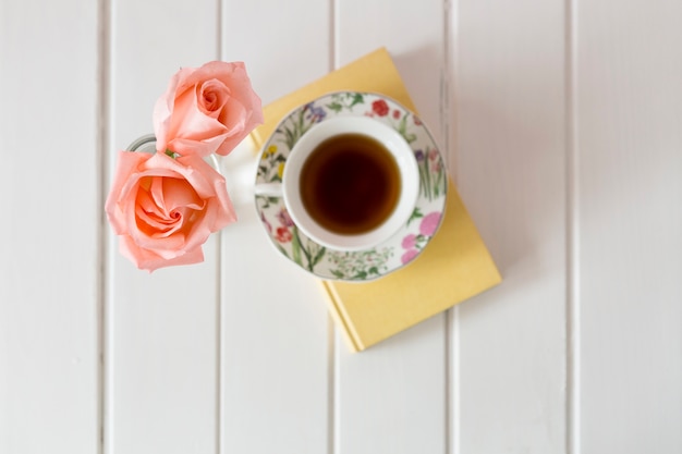 Draufsicht auf tasse tee mit zwei dekorative blumen