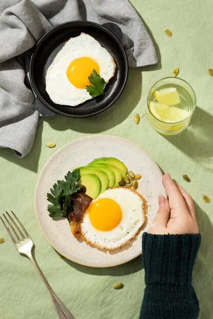 Draufsicht auf Teller mit Keto-Diät-Essen und Glas mit Wasser und Zitrone