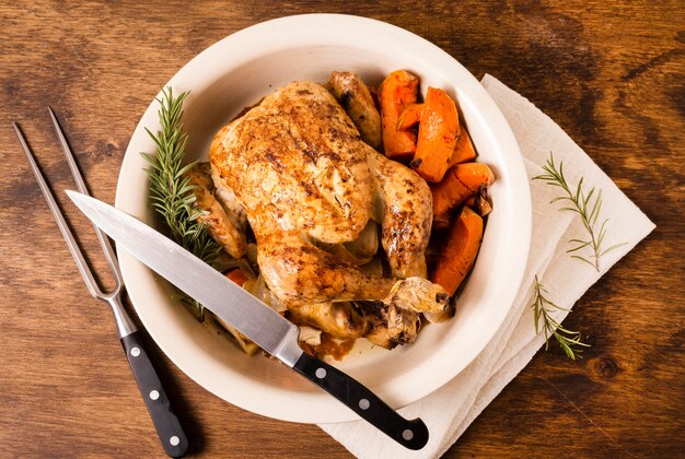 Draufsicht auf Teller mit Thanksgiving-Brathähnchen und Besteck