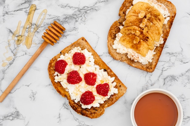 Draufsicht auf Toast mit Himbeeren und Honigschöpflöffel