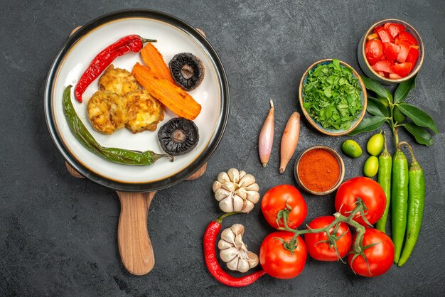 Draufsicht auf Tomaten buntes Gemüse Gewürze Kräuter das appetitliche Gericht auf dem Brett