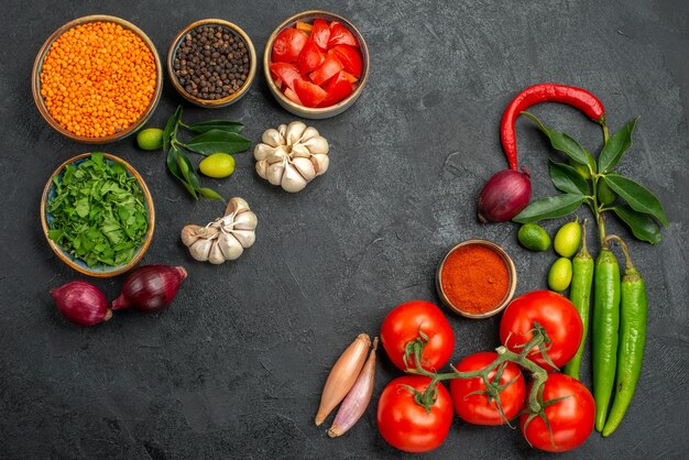 Draufsicht auf Tomatenschalen mit Linsenzwiebeln Knoblauchkräuter Gewürze Tomaten Paprika