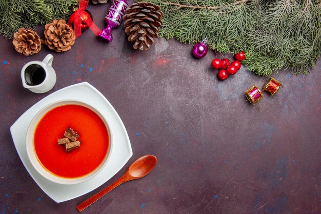 Draufsicht auf Tomatensuppe mit geschnittenem Brot im Inneren auf Schwarz