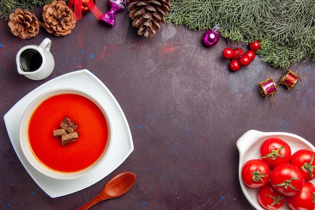 Draufsicht auf Tomatensuppe mit geschnittenem Brot im Inneren auf Schwarz