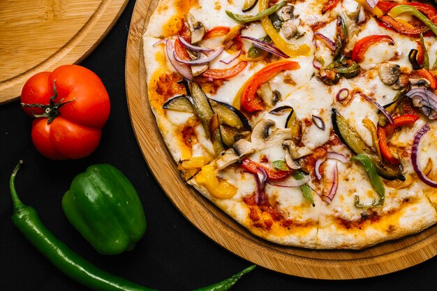 Draufsicht auf vegetarische Pizza mit Auberginen, Paprika, roten Zwiebeln, Tomaten und Pilzen