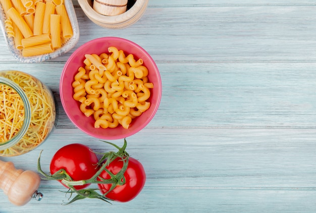 Draufsicht auf verschiedene Arten von Nudeln als Cavatappi Ziti Spaghetti mit Tomatensalz auf Holzoberfläche mit Kopierraum