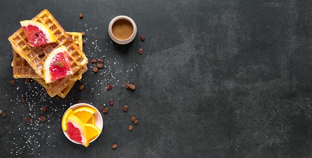 Draufsicht auf Waffeln mit Zitrusfrüchten und Rosinen