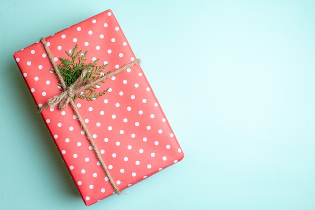 Draufsicht auf Weihnachtshintergrund mit Geschenkbox auf der rechten Seite auf pastellgrünem Hintergrund