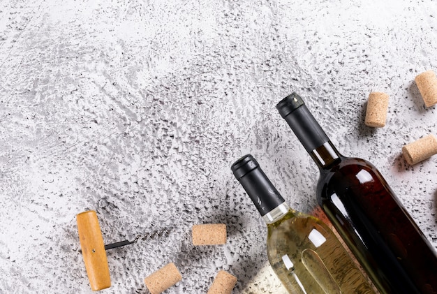 Draufsicht auf Weinflaschen mit Korkstopfen und Kopierraum auf weißem Stein horizontal