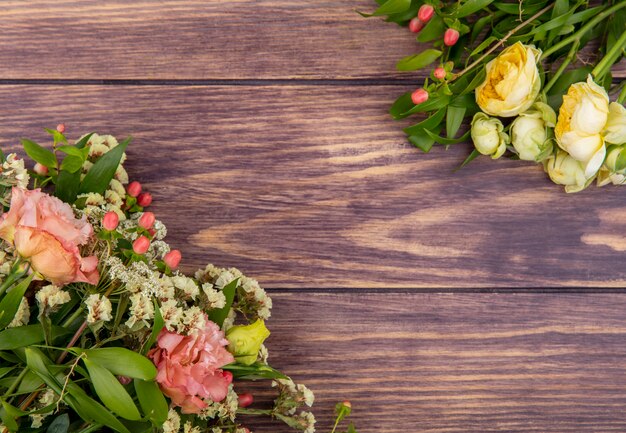 Draufsicht auf wunderbare und frische Blumen wie Pfingstrosen und Rosen auf einer Holzoberfläche