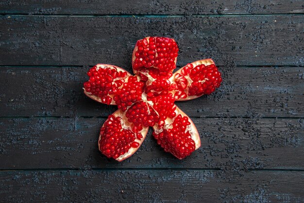 Draufsicht aus der Ferne roter Granatapfel appetitlicher roter Granatapfel in der Mitte des grauen Tisches