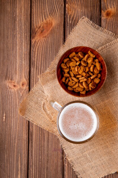 Draufsicht Becher Bier mit hartem Futter in Schüssel rechts mit Kopienraum auf Holztisch