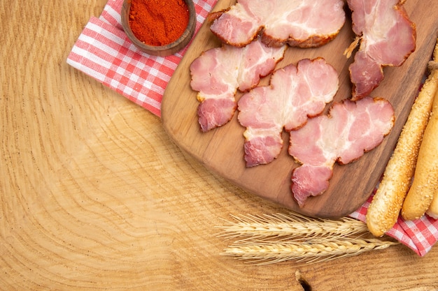 Draufsicht Becon Scheiben auf Holzbrett Paprika in Schüssel Brotweizen Spike bread