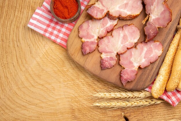 Draufsicht Becon Scheiben auf Holzbrett Paprika in Schüssel Brotweizen Spike bread