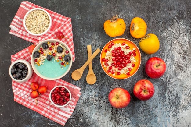 Draufsicht Beerenschalen von Kaki-Beeren Haferflocken auf der Tischdecke