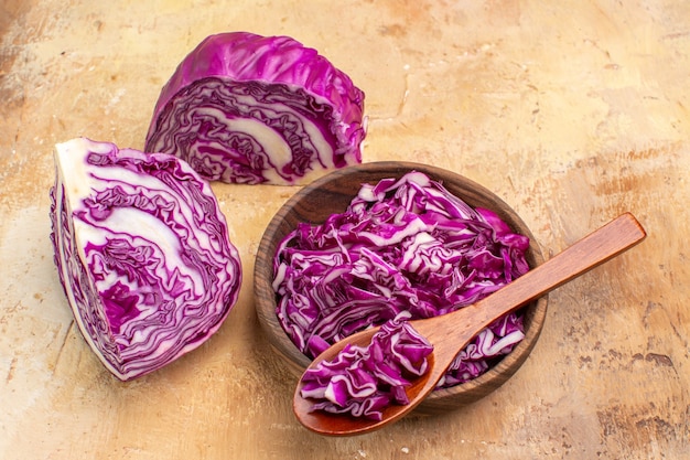 Draufsicht bereiten Sie eine Schüssel mit gehacktem Rotkohl für Rübensalat auf einem hölzernen Hintergrund mit Kopienplatz in der oberen rechten Ecke vor