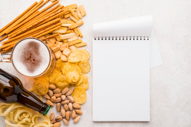 Draufsicht Bier, Snacks und Notizbuch