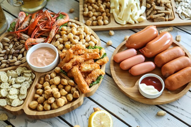 Draufsicht Bier Snacks Würstchen mit gebratenen Erbsen Pistazien Croutons Garnelen mit Käse und Saucen auf Ständen