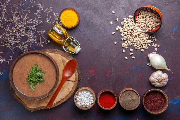 Draufsicht Bohnensuppe köstliche gekochte Suppe mit Gewürzen auf der dunklen Oberfläche Suppe Bohnenfarbe würzige Mahlzeit