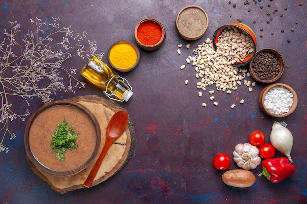 Draufsicht Bohnensuppe köstliche gekochte Suppe mit Gewürzen auf dunkler Schreibtischsuppe Bohnenfarbe würzige Mahlzeit