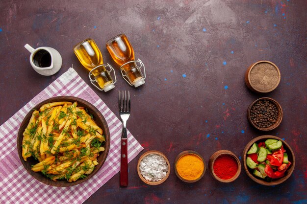 Draufsicht Bratkartoffeln leckere Pommes Frites mit Grün und Öl auf dem dunklen Schreibtisch