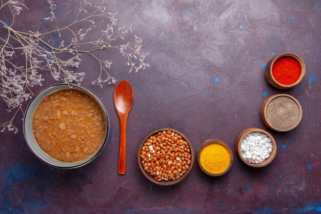 Draufsicht braune Suppe mit verschiedenen Gewürzen auf dunkler Oberfläche Suppe Gemüsemehl Lebensmittel Küchenöl