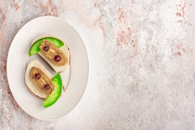 Draufsicht Brot Toast mit Pastete und Gurkenscheiben innerhalb Platte auf dem weißen Schreibtisch Fleisch Gemüse Essen Mahlzeit Toast Sandwich