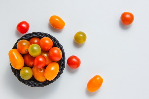 Draufsicht bunte Tomaten in der Schüssel und auf weißem Hintergrund. horizontal