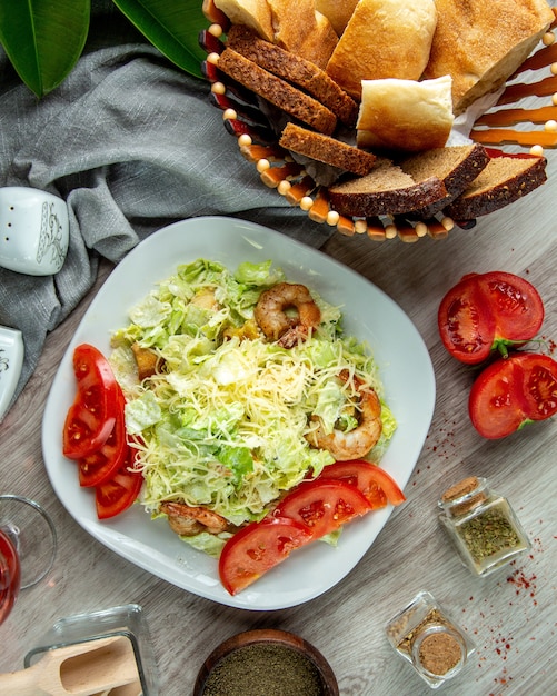 Kostenloses Foto draufsicht caesar salat mit garnelen tomatenscheiben und einem glas erfrischungsgetränk