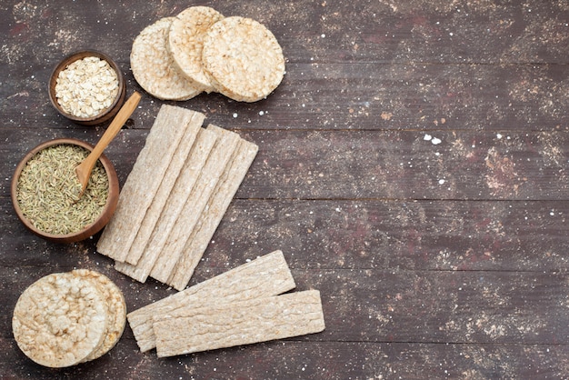 Draufsicht Chips und Cracker lang und rund mit getrockneten Gewürzen auf Holz geformt