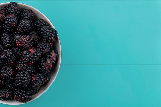 Draufsicht der Brombeere in einer Schüssel auf einer hellblauen Oberfläche