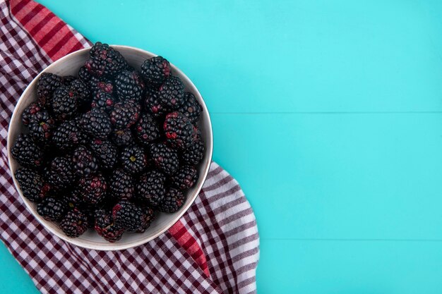 Draufsicht der Brombeere mit rotem kariertem Handtuch auf einer türkisfarbenen Oberfläche