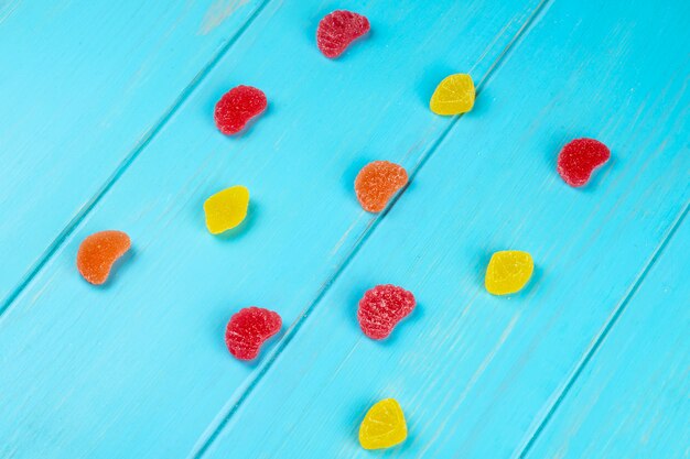 Draufsicht der bunten leckeren Marmeladenbonbons auf Blau