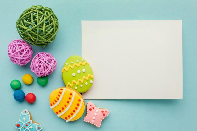 Draufsicht der bunten Ostereier mit Schmetterling und Papier