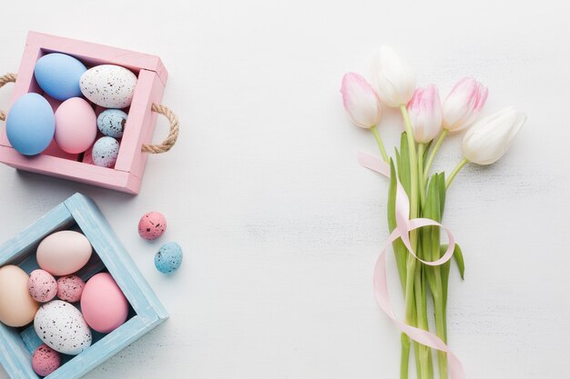 Draufsicht der bunten Ostereier mit schönen Tulpen