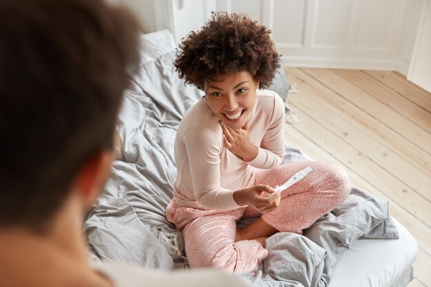 Draufsicht der Cheerul schwarzen zukünftigen Mutter trägt Pyjamas